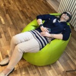 Pani leży na pufie sako. Testuje urządzenie AVS.