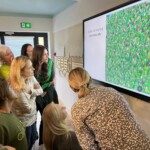 Uczestnicy forum skupieni nad wyszukiwaniem ukrytego na obrazie szczegółu.